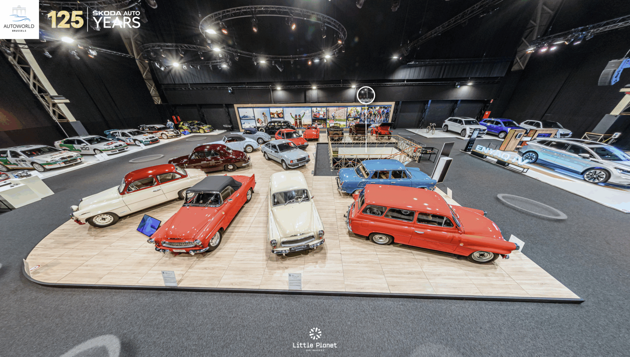 A panoramic view of a Škoda exhibit at Autoworld Brussels featuring classic and modern cars, with a prominent 125 years celebration banner.
